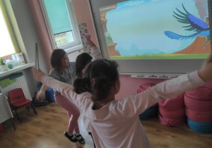 Dzieci naśladują sposoby poruszania się dinozaurów.